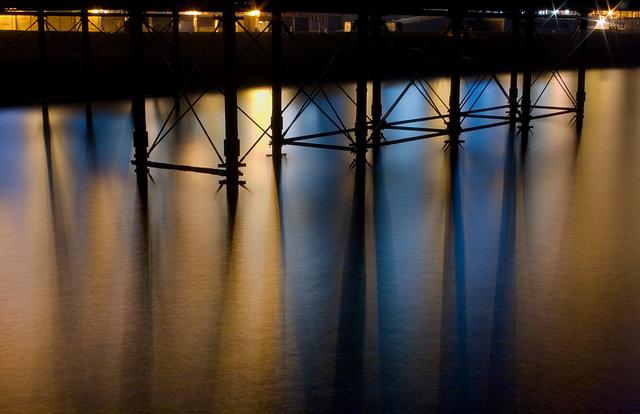 Seafront Lights Reflected Beneath Brighton Pier Structural Supports (Long Exposure)